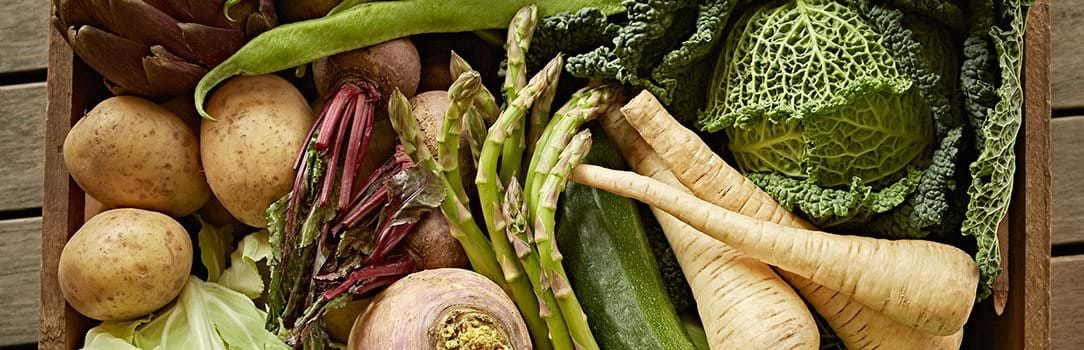 Overhead view of an assortment of fresh vegetables in a crate.