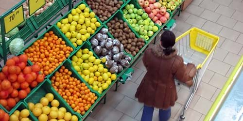 Woman with shopping cart in the produce aisle