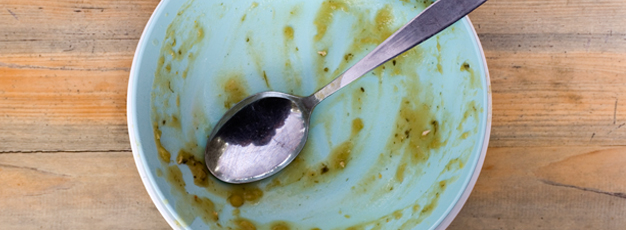 An empty soup bowl with a spoon