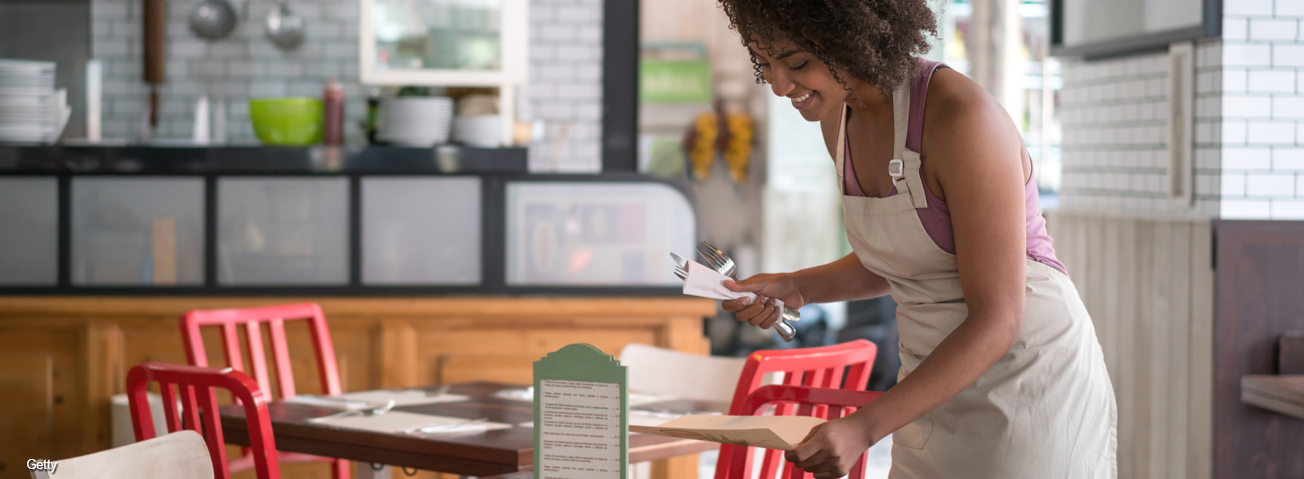 African American waitress setting table