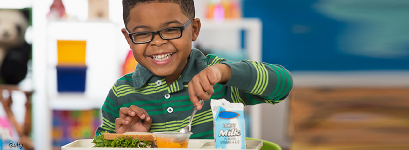 Young boy eating school lunch.