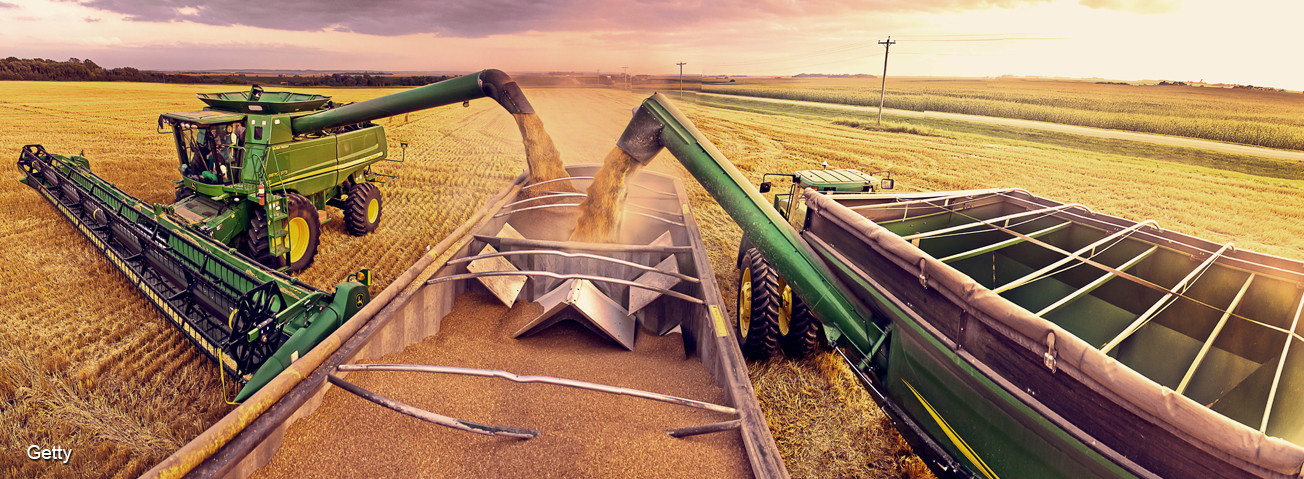 Tractors unloading grain into a trailer