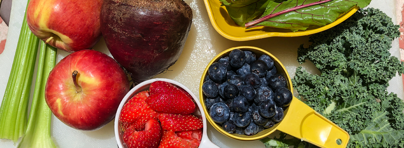 Tabletop with a variety of fresh fruits and vegetables.