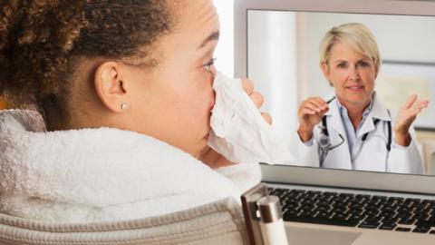 Sick woman video chatting with doctor on laptop