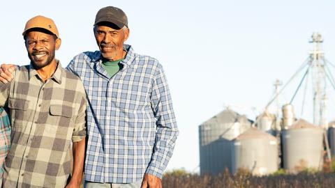 Family of farmers in front of silos