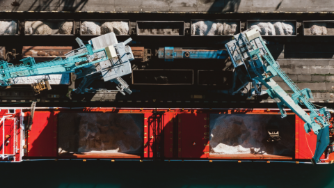 Ship loading fertilizer at a port.