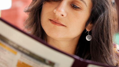 Photo of woman reading a restaurant menu.